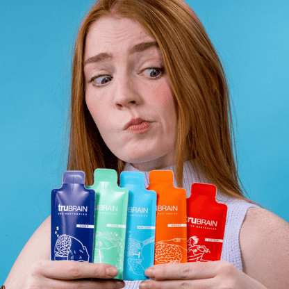 Creative professional woman holding the 5 1oz high function nootropic drinks with both hands in a row, wondering which to choose