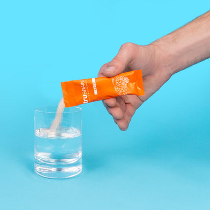 TruBrain’s Powder stick ripped open poured into a glass of water to show how the Nootropic Powder with in Stick Packs is dissolved in water
